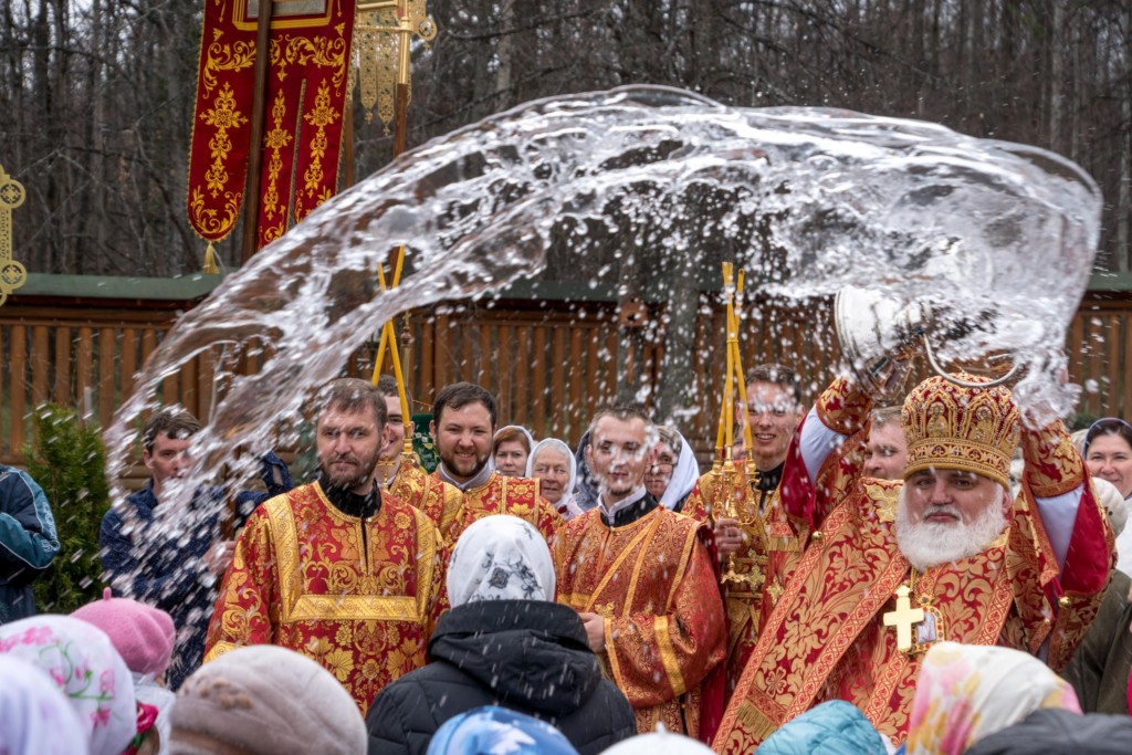 Священник освящает